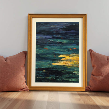 Abstract Goldfish Pond art print in a natural light wood frame (oak/maple), leaning against a gray wall on the floor between two terracotta-colored pillows, demonstrating a grounded decor style.