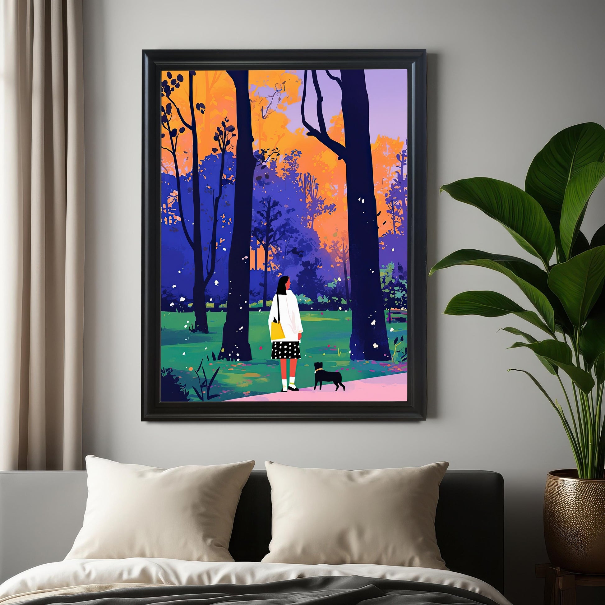 A framed piece of wall art hangs on a gray wall above a bed. The art depicts a woman and a small black dog walking through a park with colorful trees. The frame is black. A large potted plant sits on the floor to the right of the frame.