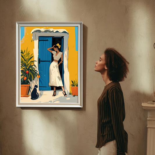 A woman with curly hair looks up at the framed artwork, which is hung on a wall. The artwork is in a silver/white frame. The woman is standing next to a white decorative fireplace mantel.