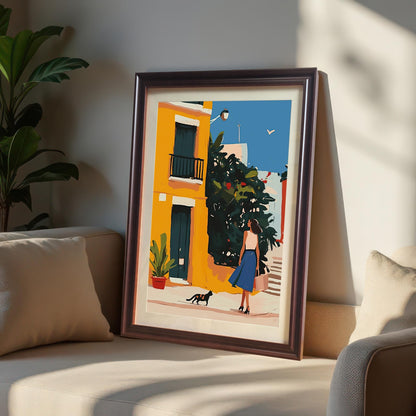 Coffee wood framed wall art print of a woman and a cat in a colorful alley, leaning against a sofa. A perfect decor piece for adding a touch of European charm to your home.