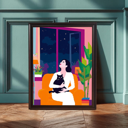 A large wall art print with a black wood frame, leaning against a teal paneled wall. The artwork, featuring a seated woman and a cat looking at the stars, contrasts beautifully with the wall color, creating a stylish and inviting interior design.