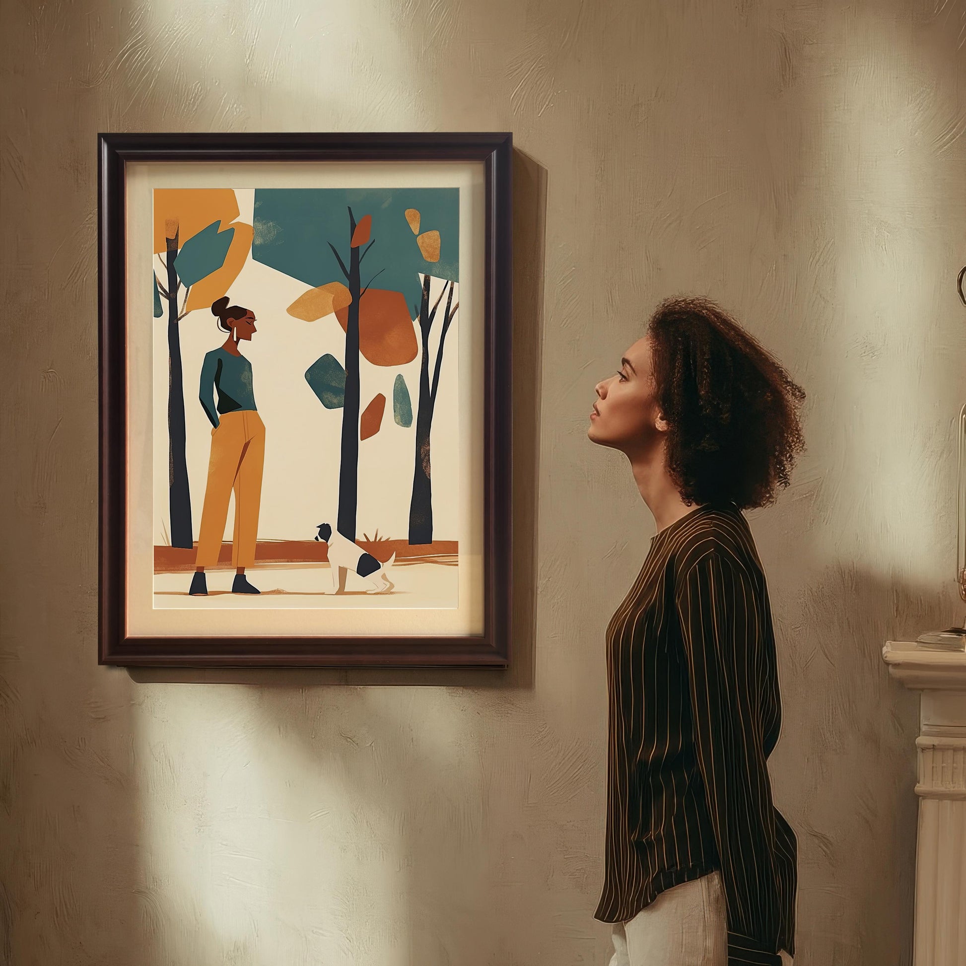 A framed art print of a woman and a dog in a park, hanging on a beige wall. A woman with curly hair looks at the print.