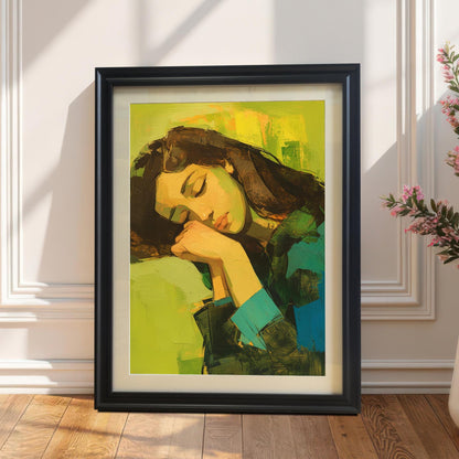 A vertical wall art print with a black frame, resting on a light wood floor against a white wall. The painting is an abstract portrait of a woman with dark hair, sleeping with her head on her hands, against a bright yellow and green background. A tall plant with pink flowers in a white vase is visible to the right.