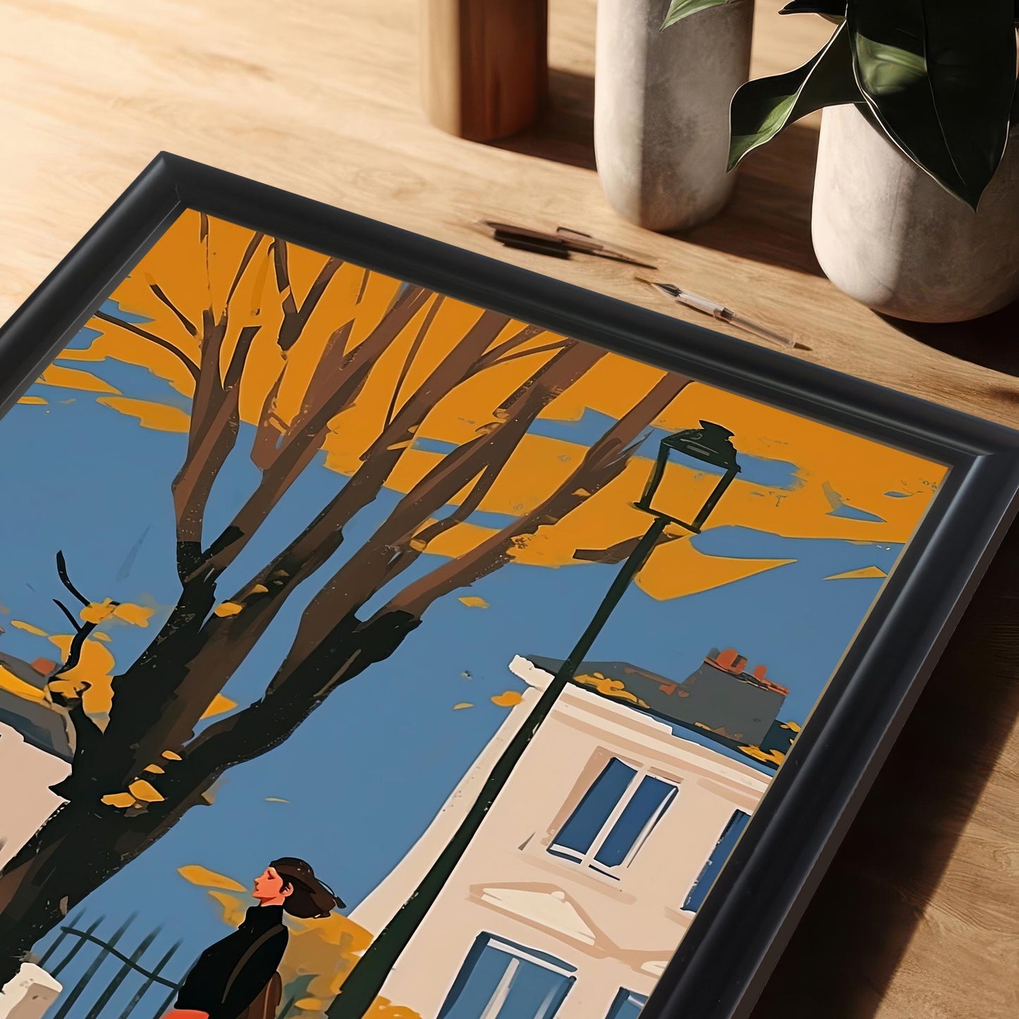 A close-up, angled view of a framed art print showing a woman and a black cat walking on a city street in autumn.