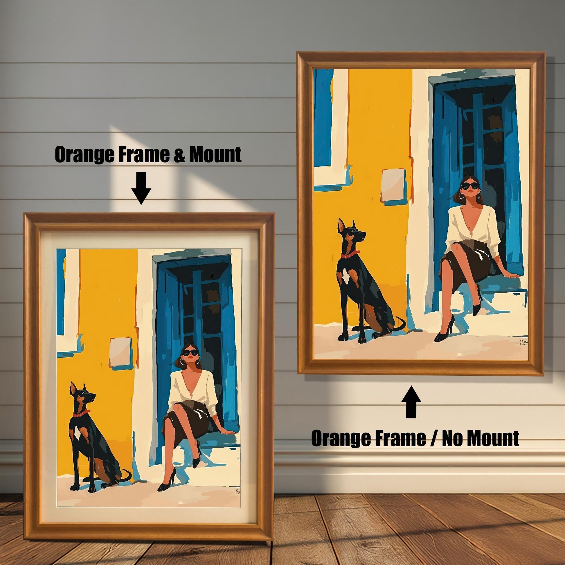 A split image showing two different framing options for the same artwork. On the left, a framed print with an orange wood-tone frame and a white mat (mount) is labeled "Orange Frame & Mount." On the right, the same print is shown in an orange wood-tone frame without a mat, labeled "Orange Frame / No Mount." Both images are against a rustic wood-paneled wall. The art depicts a woman sitting on a step next to a Doberman dog.