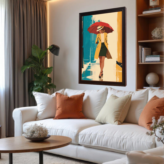 A vertical framed artwork hangs above a white sofa. The artwork depicts a woman in a yellow coat and a white hat, holding a red umbrella, walking down a street with blue and yellow buildings. The room has a contemporary design with a plant, a floor lamp, and a bookshelf.