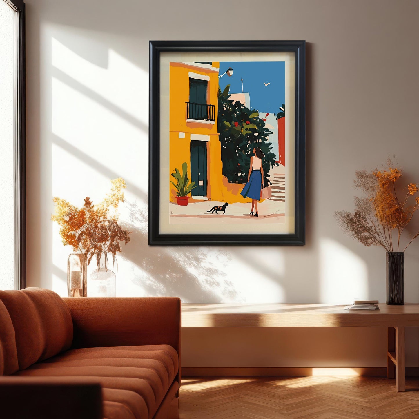 Black framed wall art print of a woman and a cat walking down a colorful alley, hanging above a mid-century modern bench in a living room. An artistic and eye-catching print that brings life to a space.