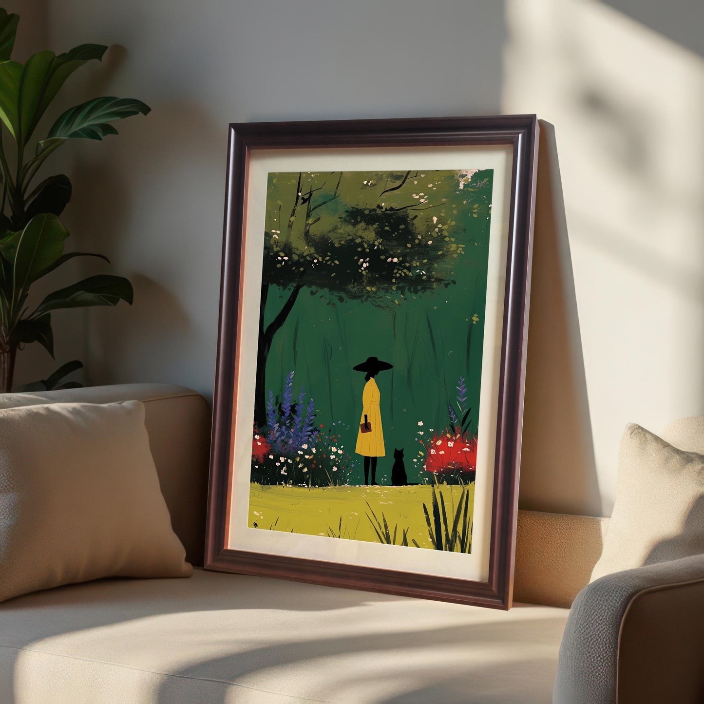 Coffee wood framed art print of a woman and a cat in a green garden. The framed artwork is leaning on a beige couch, highlighting its potential to add a pop of color to neutral-toned rooms.