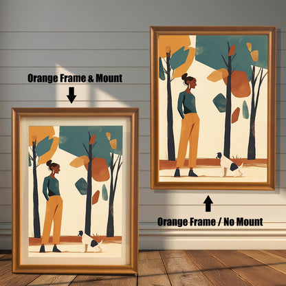 Two framed art prints of a woman and a dog in a park. The left print has an orange-colored frame and a white mat ("mount"), while the right print has an orange-colored frame with no mat.