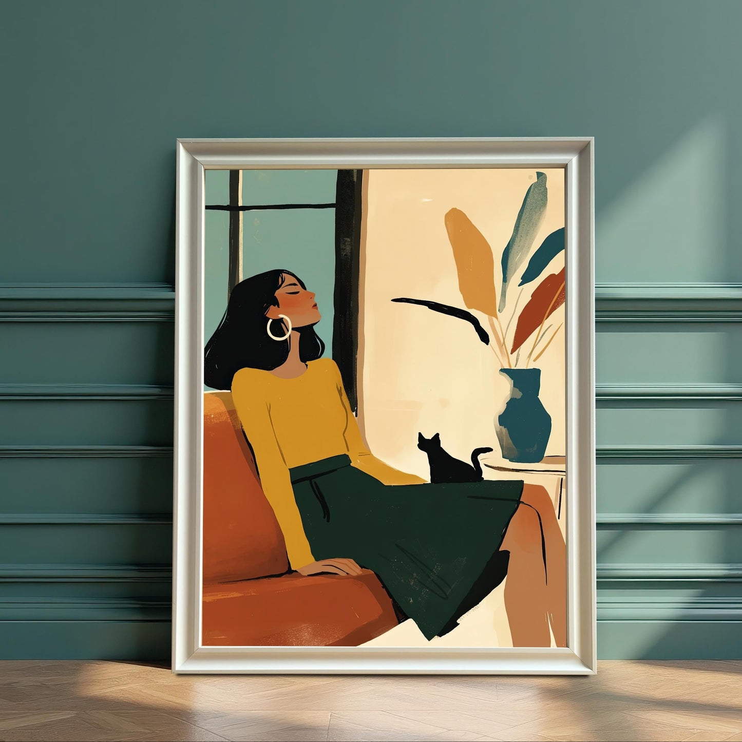 A framed art print showing a woman in a yellow sweater and green skirt relaxing on a couch with a black cat. The white frame leans against a teal wall.