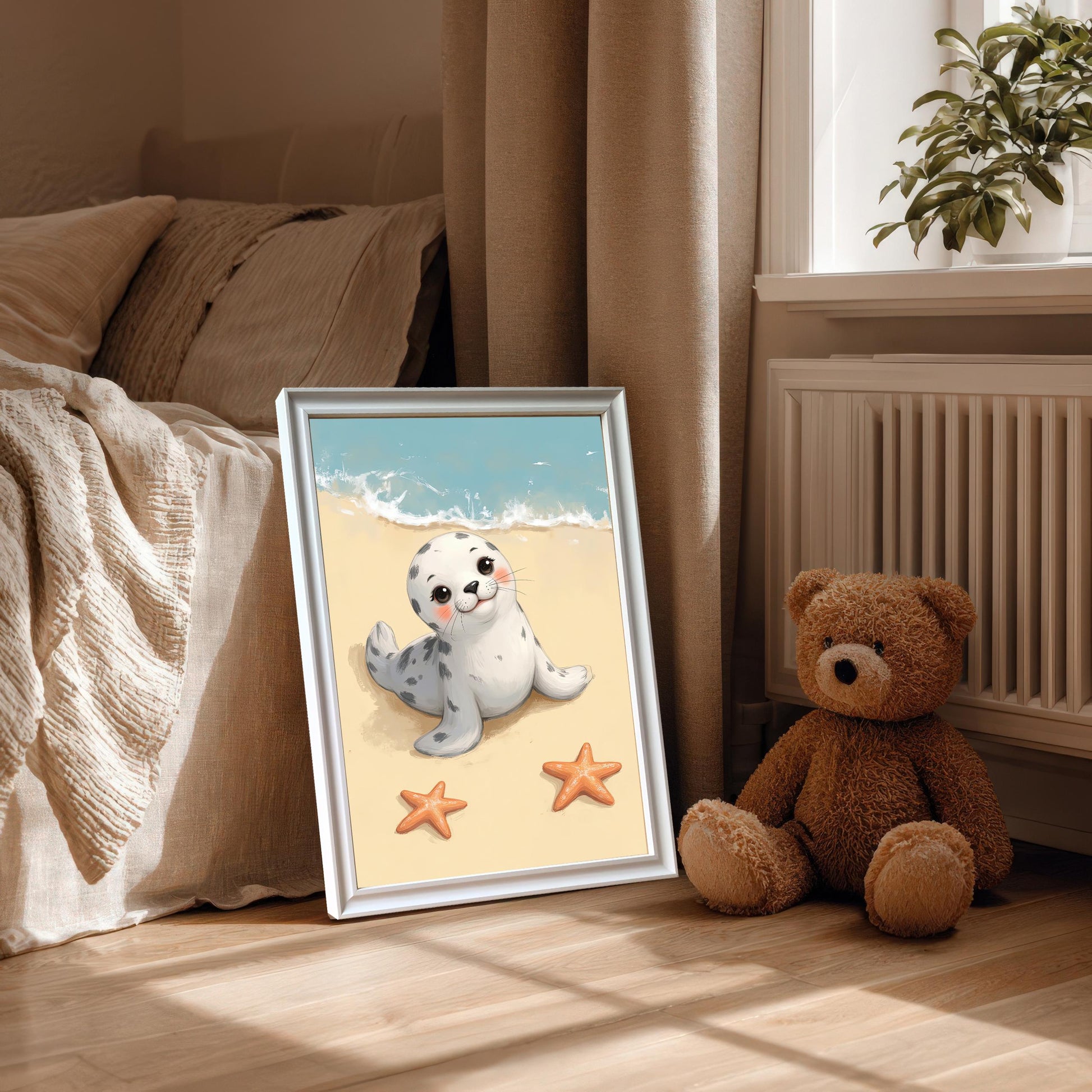A framed wall art print of a cute baby seal on a beach, with a mount and a white frame. The print is propped on the floor next to a bed and a teddy bear, bathed in natural light.