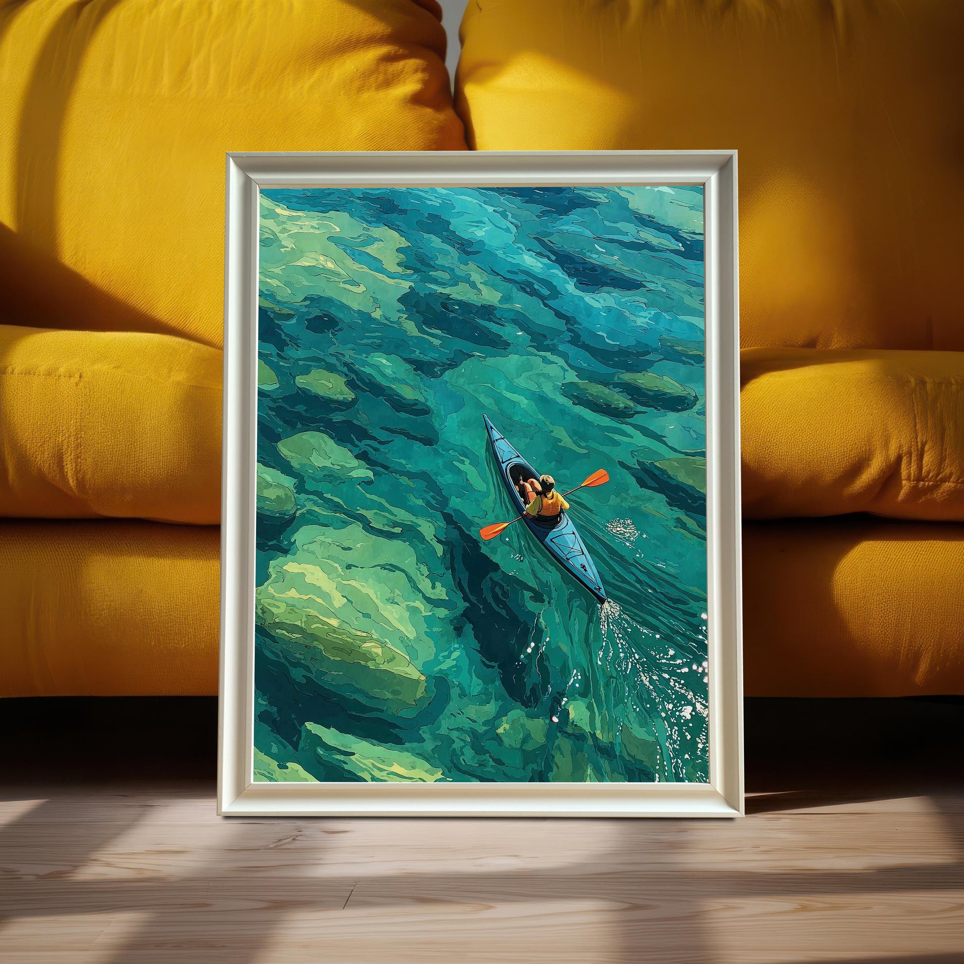 A framed art print of a person in a kayak on clear turquoise water leans against a vibrant yellow couch.