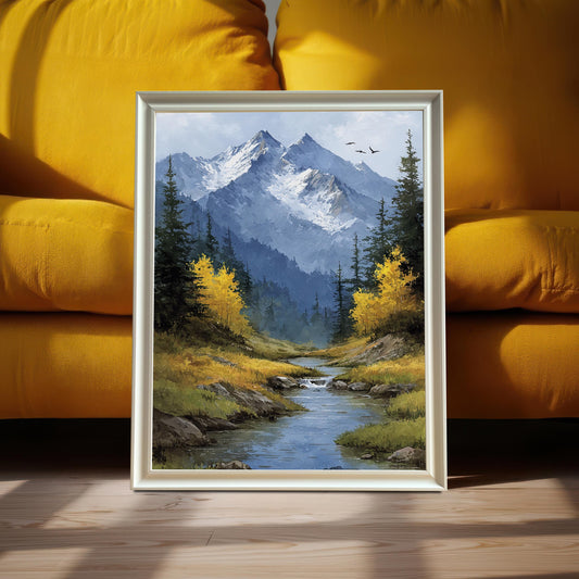 A white-framed art print of a mountain landscape with a stream and yellow trees leans against a vibrant yellow couch.