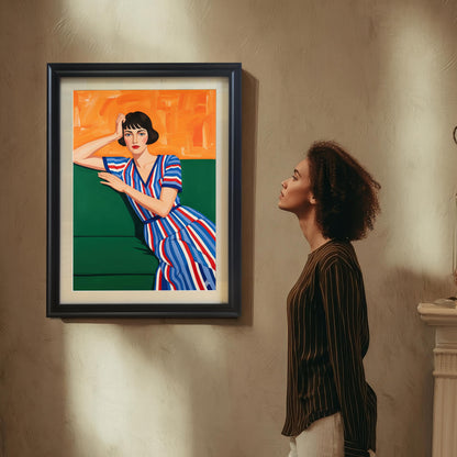 A woman with curly hair, wearing a striped shirt, looks up at a black-framed art print of a seated woman. The print hangs on a textured wall above a fireplace mantel.