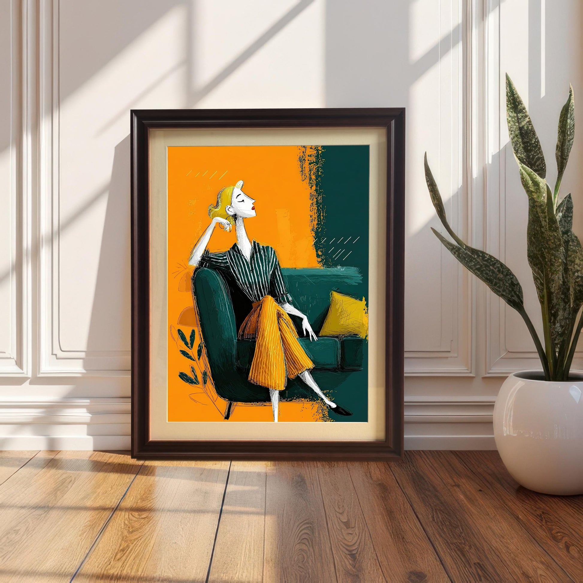 A framed art print in a coffee-colored frame with a mount leaning against a white paneled wall and resting on a wood floor. A large potted snake plant is next to it.