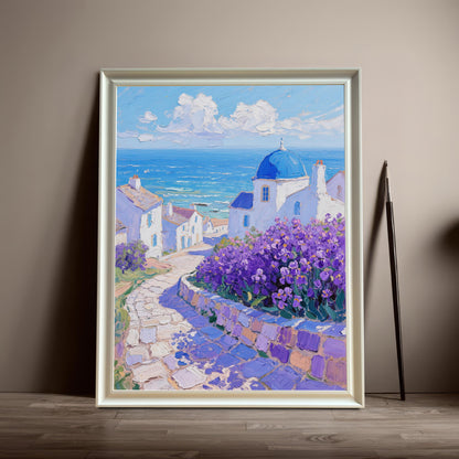 A framed painting of a Greek village with a blue-domed church and purple flowers rests on the floor against a tan wall. The frame is white.