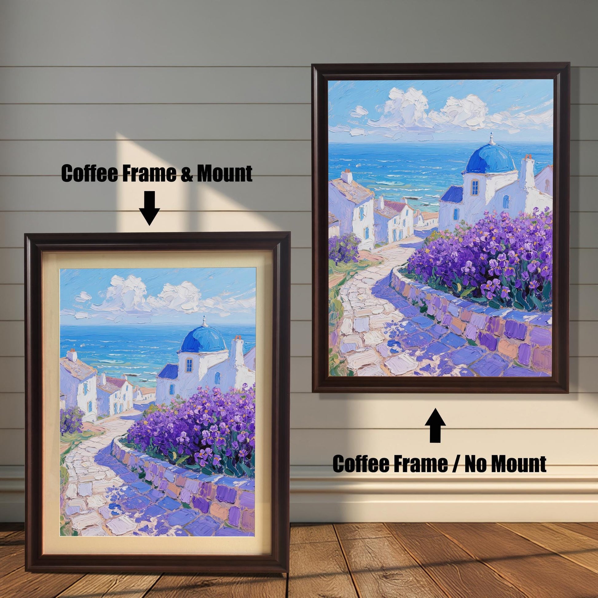 A painting of white houses with a blue dome by the sea is shown in two coffee-colored frames against a wood wall. One has a mount, while the other doesn't, highlighting the different framing options.