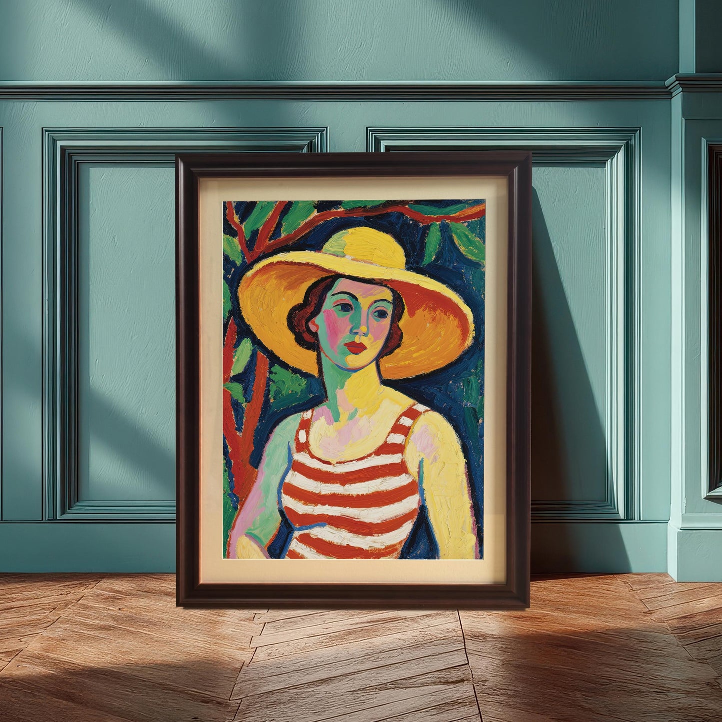 A framed art print of a woman in a striped top and yellow hat, propped against a dark blue-green wall with wainscoting. The frame is coffee-colored.