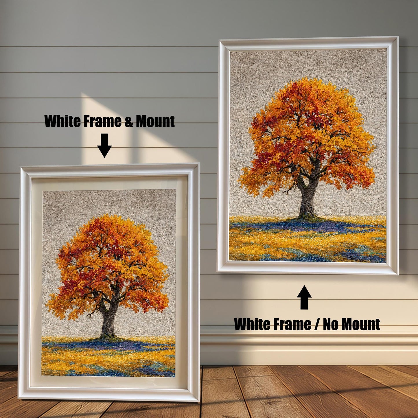 Two framed art prints of an autumn tree are on a wooden floor. The print on the left is in a white frame with a mount, and the one on the right is in a white frame without a mount.