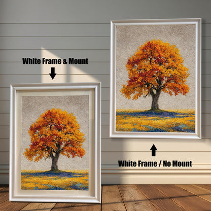 Two framed art prints of an autumn tree are on a wooden floor. The print on the left is in a white frame with a mount, and the one on the right is in a white frame without a mount.