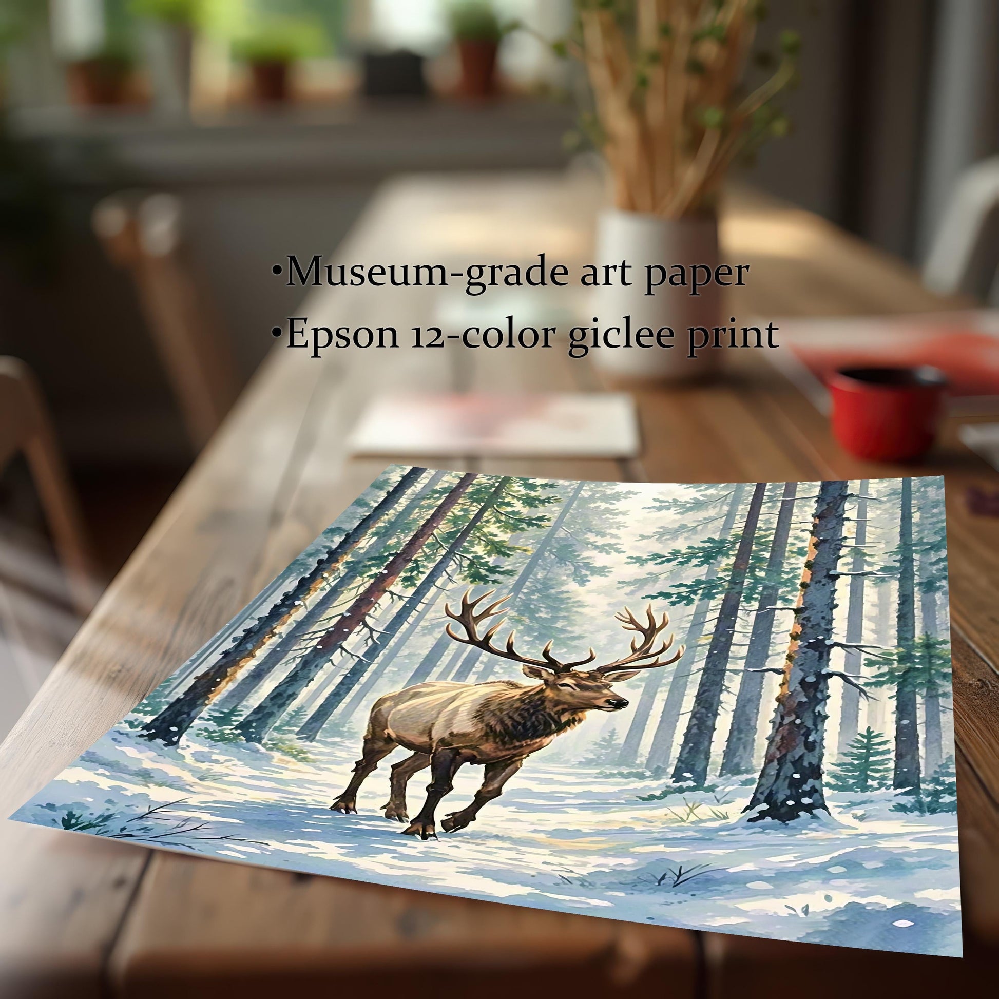 An angled close-up of a print showing an elk in a winter forest, lying on a wooden table. Text on the image describes it as a museum-grade giclée print.