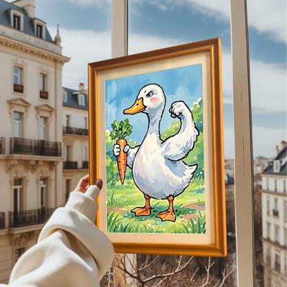 A person holds a framed print of a duck with a carrot in front of a window overlooking a city. The frame is a warm, orange wood color.