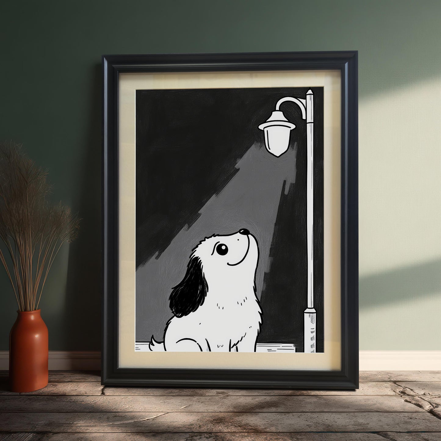 A framed black-and-white print of a cute puppy looking up at a lamppost, leaning against a green wall next to a terracotta vase with dried plants.