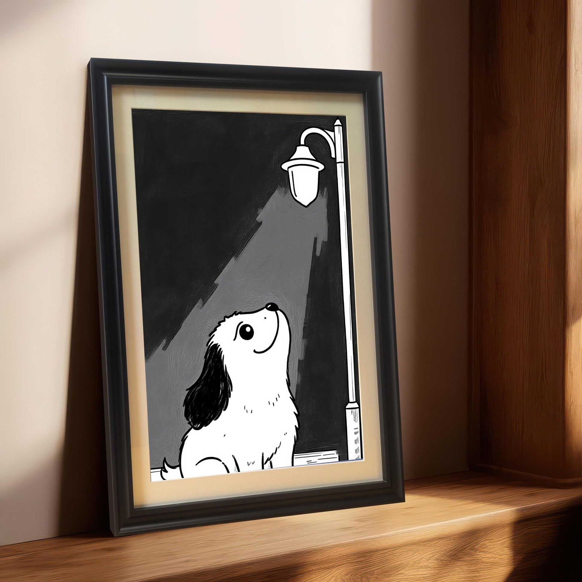 A black-framed print of a puppy under a lamppost, with a light inner border, propped on a wooden windowsill.
