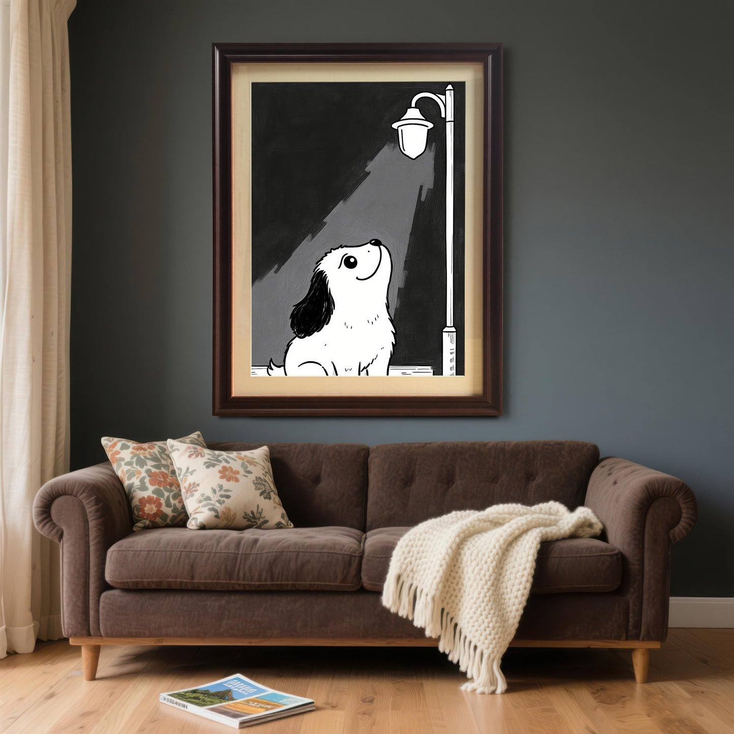 A coffee-framed print of a puppy under a lamppost hanging above a brown sofa with two pillows and a white blanket draped over it.