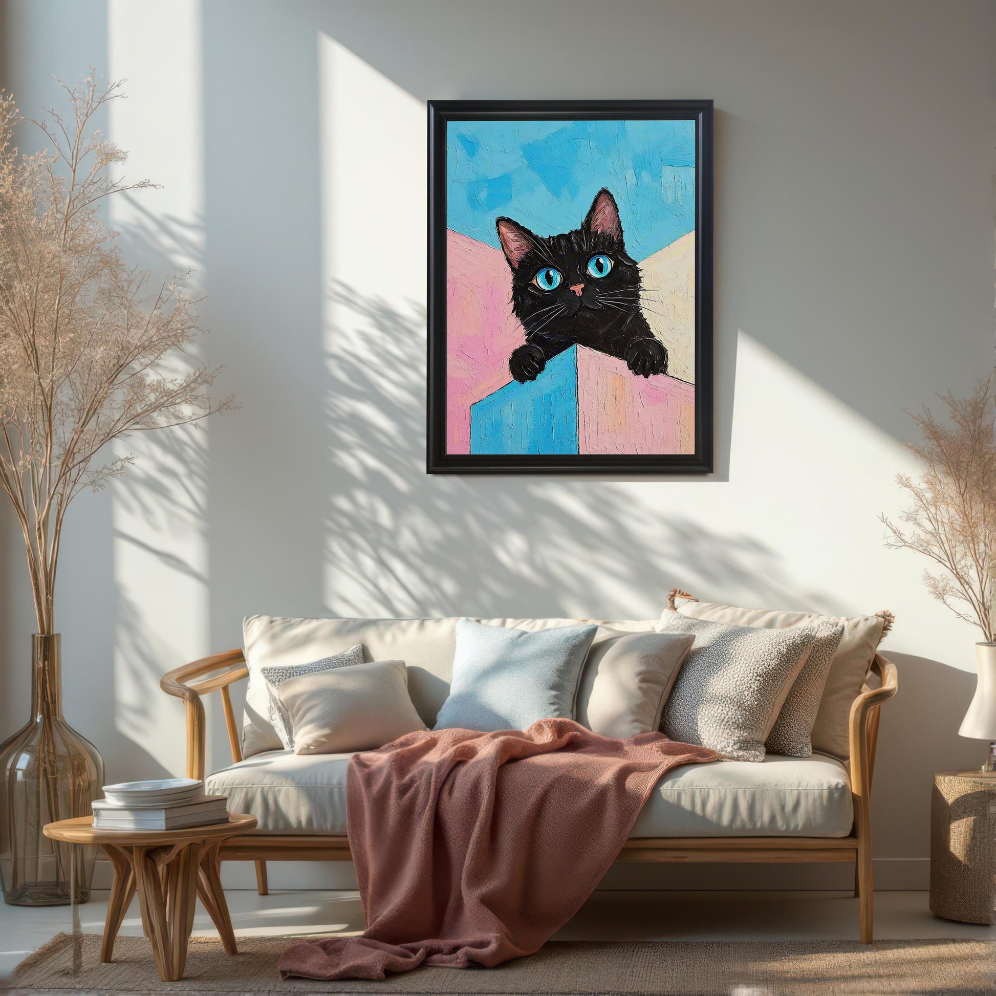 A black cat painting with vibrant blue eyes hangs on a white wall above a sofa.