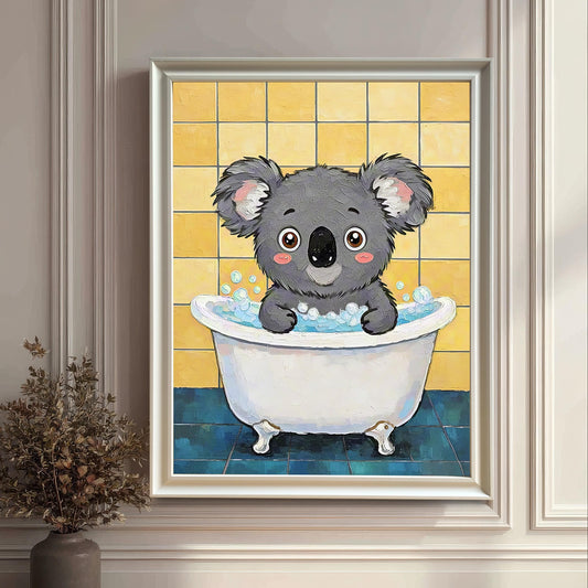 A framed art print of a koala in a bathtub, in a white frame with a white mount, hanging on a white paneled wall with a decorative trim. A vase with dried plants is on the floor.