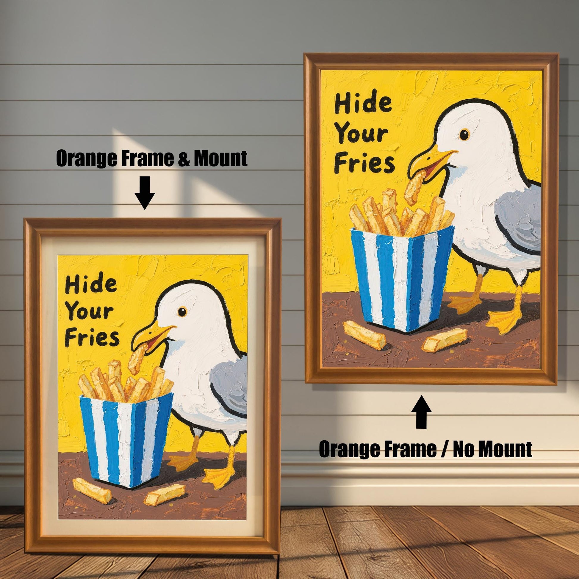 A side-by-side comparison of two framed prints of a seagull and fries. One has an orange frame with a mount, and the other has an orange frame without a mount.