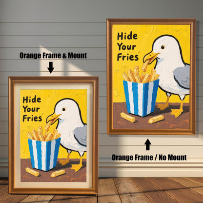 A side-by-side comparison of two framed prints of a seagull and fries. One has an orange frame with a mount, and the other has an orange frame without a mount.