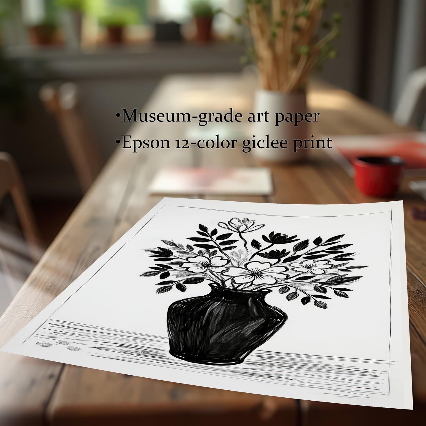 A close-up, angled shot of a black and white drawing of flowers lying on a wooden table. Text highlights its quality, noting it's on museum-grade art paper with an Epson giclee print.