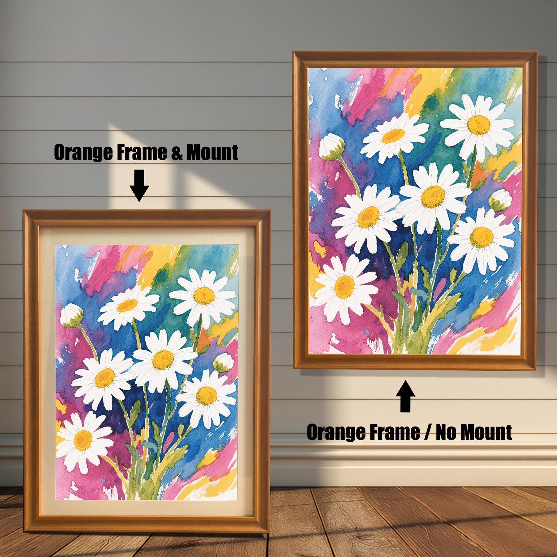 A side-by-side comparison of two framed daisy prints. The one on the left has an orange-colored frame and a cream-colored mat. The one on the right has an orange-colored frame with no mat.