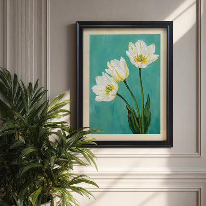 A framed art print of three white tulips with green leaves on a teal background hangs on a light gray wall. The print has a black frame and a tan mat. A large green plant is on the left.