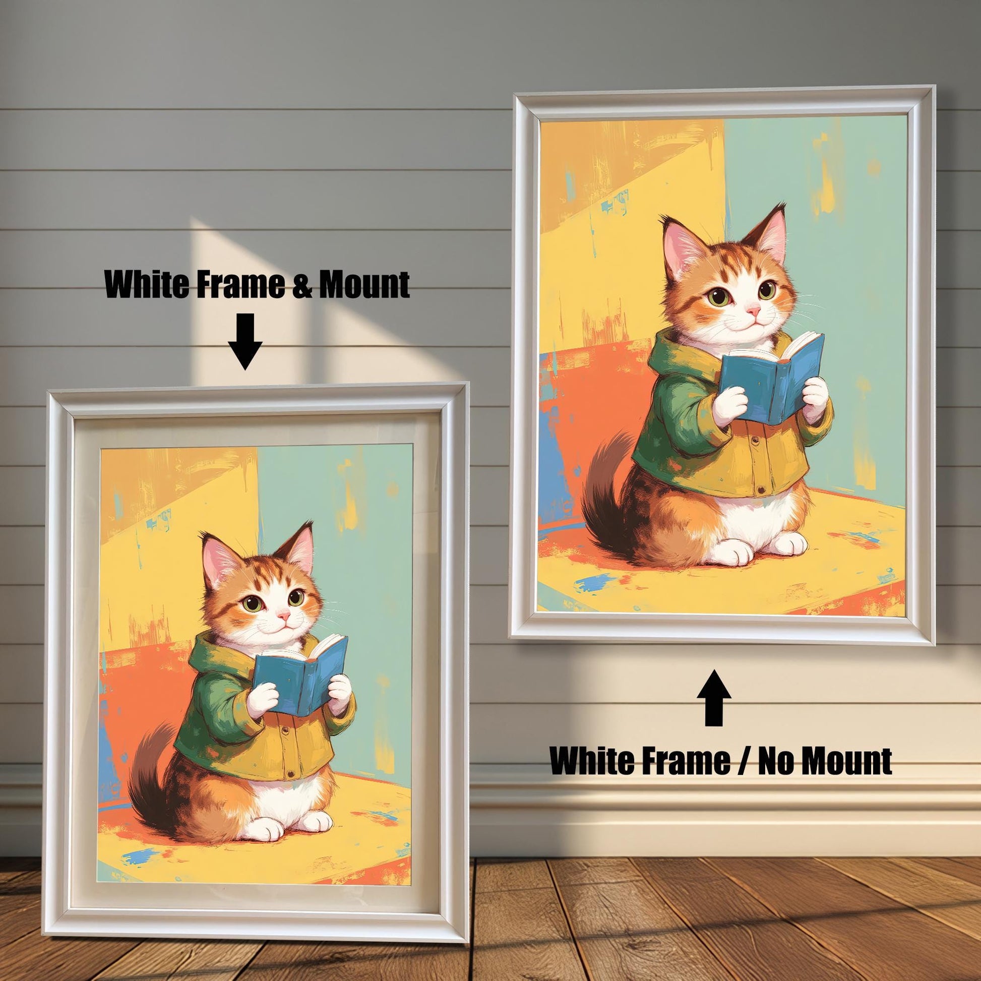 Two white-framed art prints of a cute cat reading a book. The print on the left has a white mat (mount) for a clean, classic look, while the one on the right is a full-frame display. Both pieces are leaning against a white wood paneled wall.