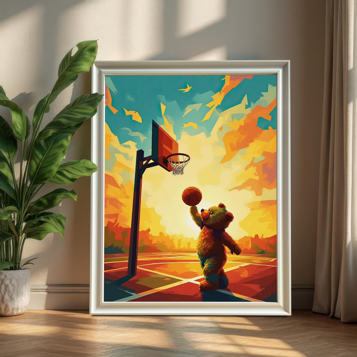 A playful bear playing basketball wall art print in a white wood frame, leaning against a wall next to a large potted plant. The print features a bear on a colorful court against a vibrant sunset.