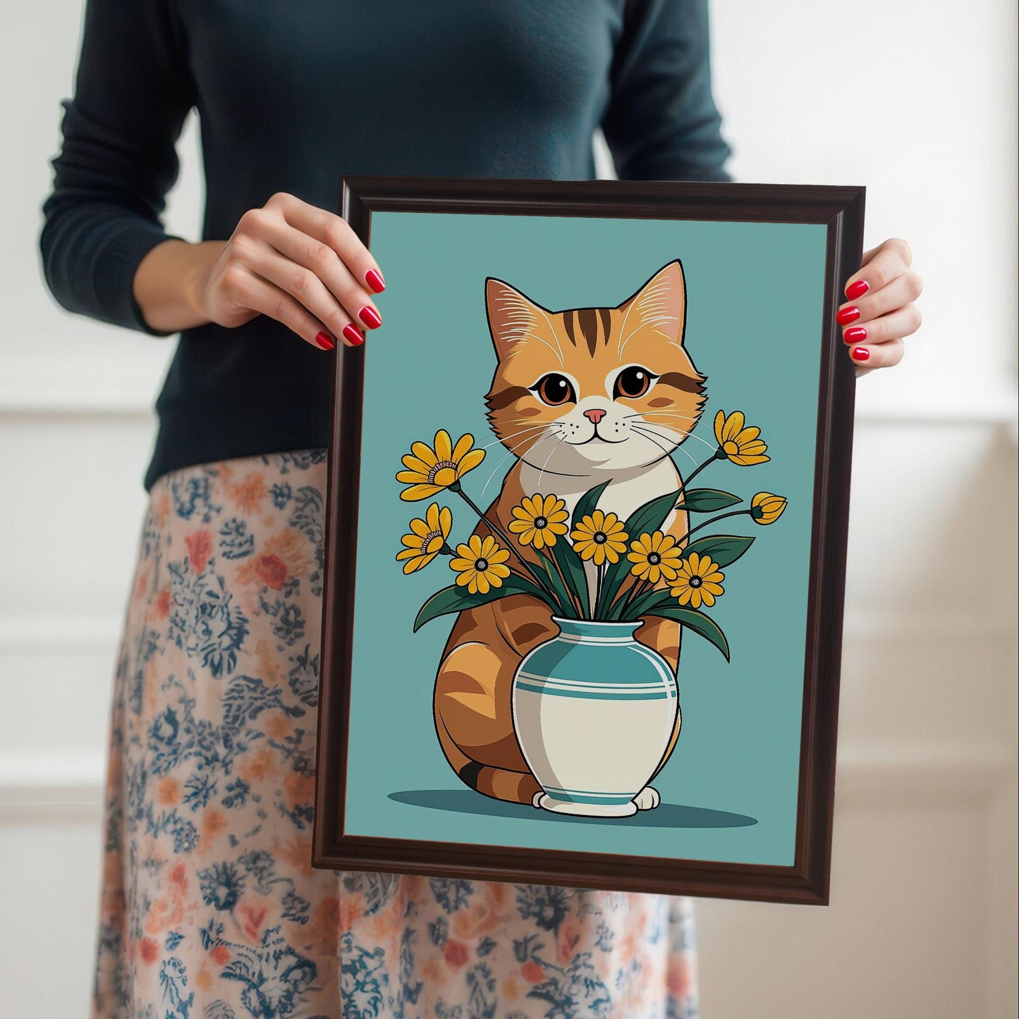A person holding a **coffee wood framed** art print of a cute ginger cat with a vase of yellow flowers. The person is wearing a dark sweater and a floral skirt, with red nail polish.