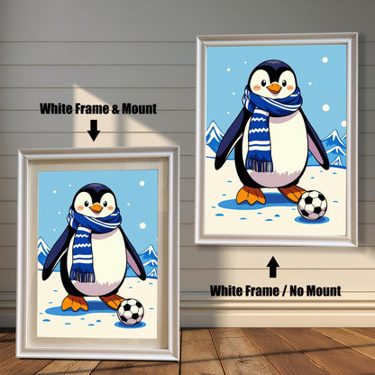 Two framed prints of a penguin playing soccer on a white wood-paneled wall. The one on the left has a white frame with a mount. The one on the right has a white frame with no mount.