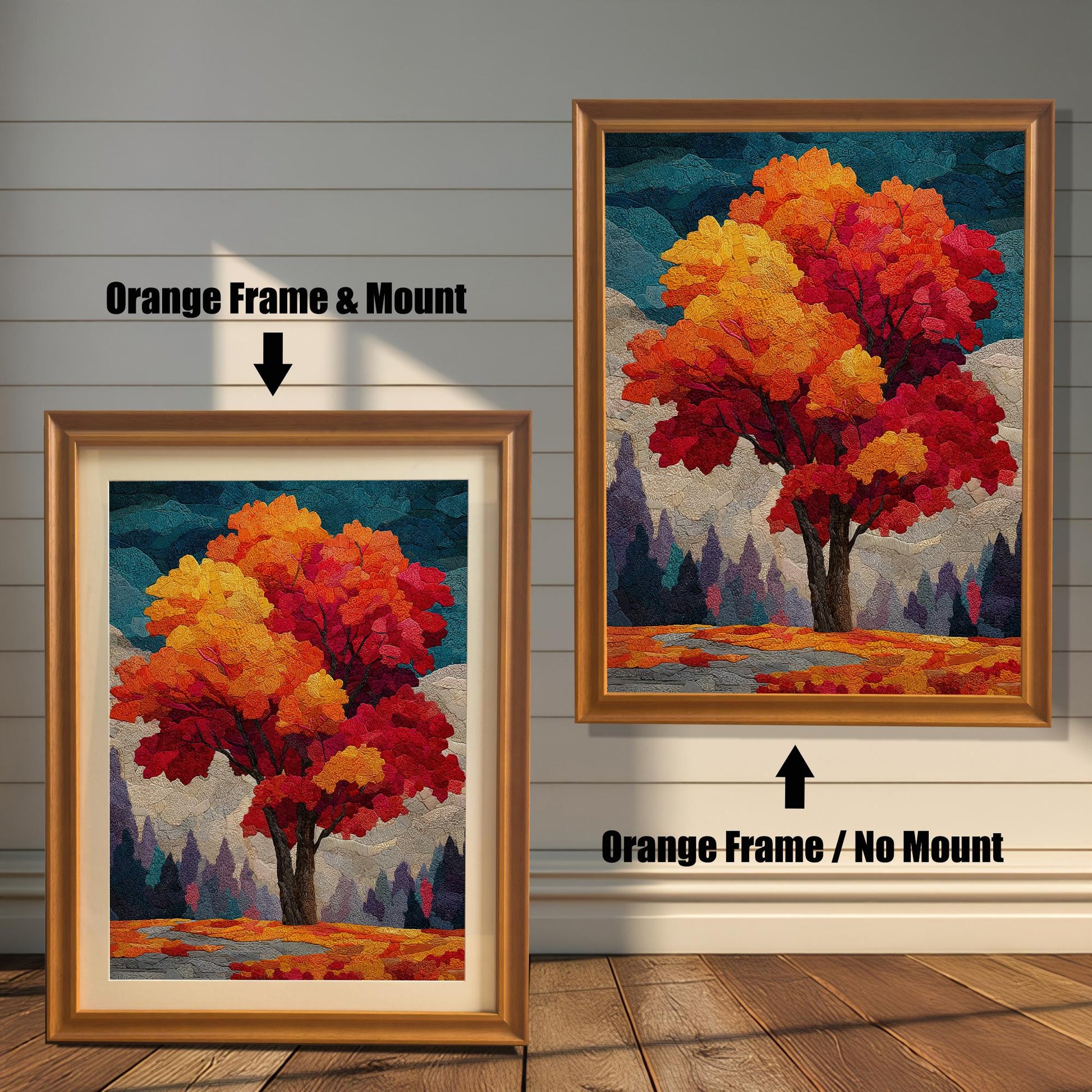 Two framed prints of an autumn tree stand on a wooden floor against a white paneled wall. The one on the left has an orange frame and a mount (mat), while the one on the right has an orange frame without a mount.