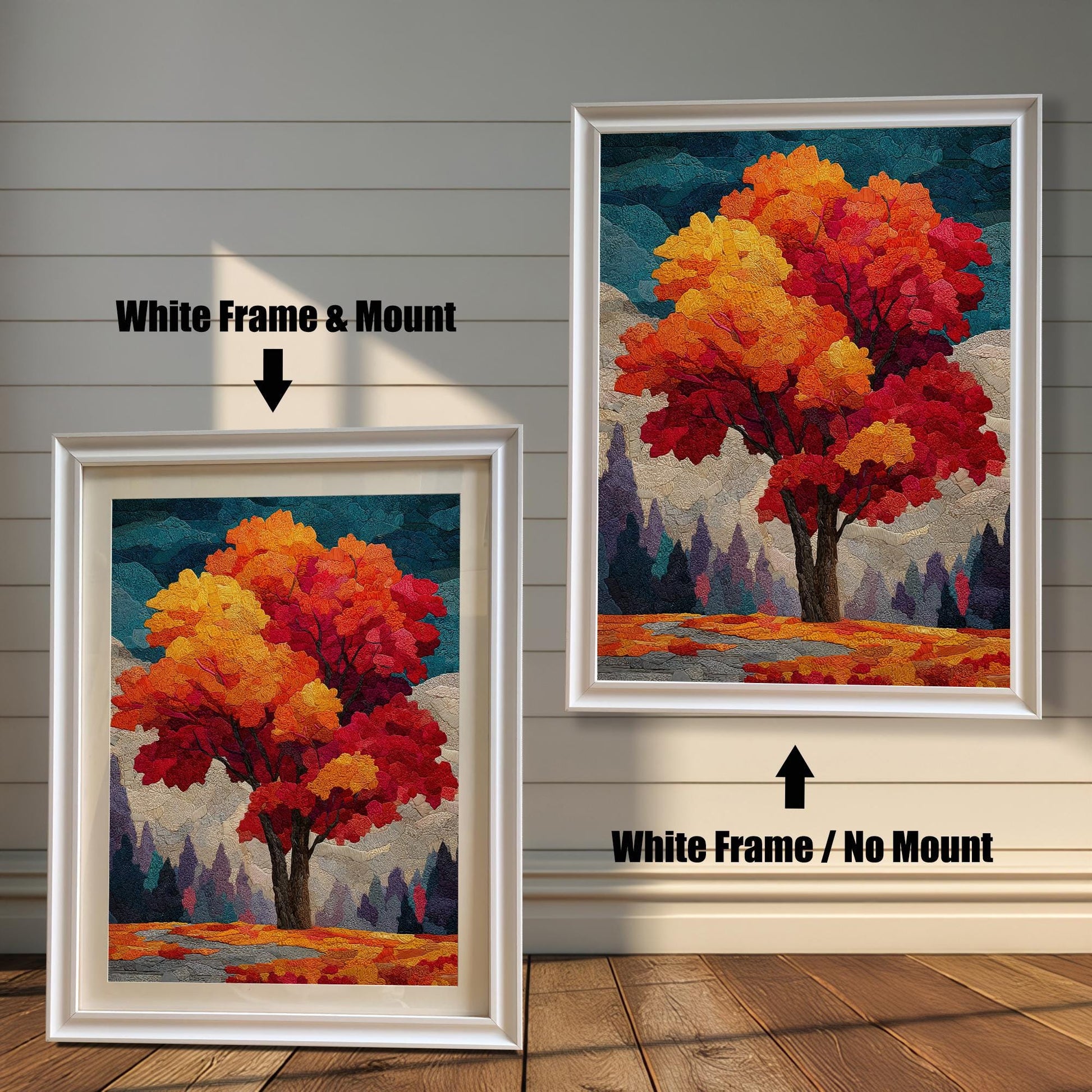 Two framed prints of an autumn tree stand on a wooden floor against a white paneled wall. The one on the left has a white frame with a mount (mat), and the one on the right has a white frame without a mount.