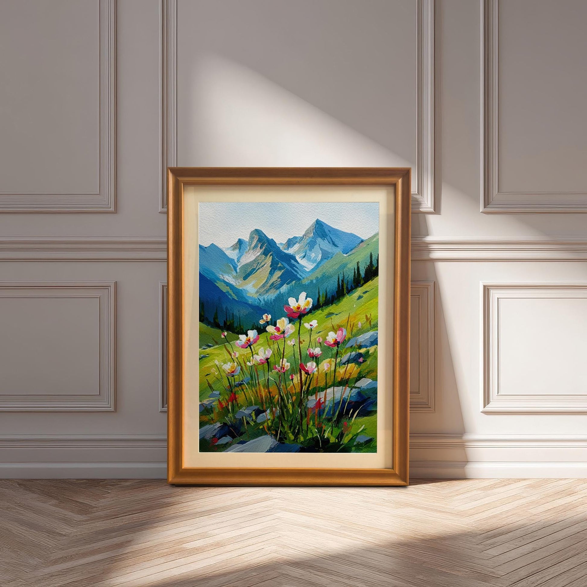 A framed painting with a golden frame and a light-colored mat board is leaning against a white wainscoted wall. The painting shows a field of flowers with mountains in the background.