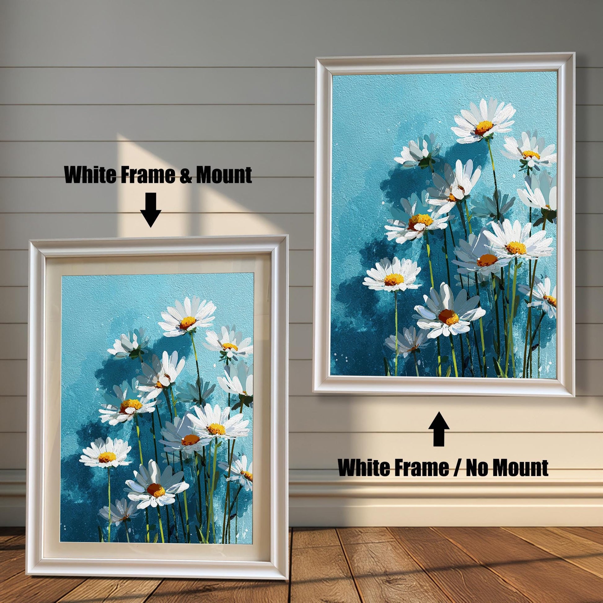 Two white-framed art prints of white daisies on a blue background. One has a white mat board and the other does not.