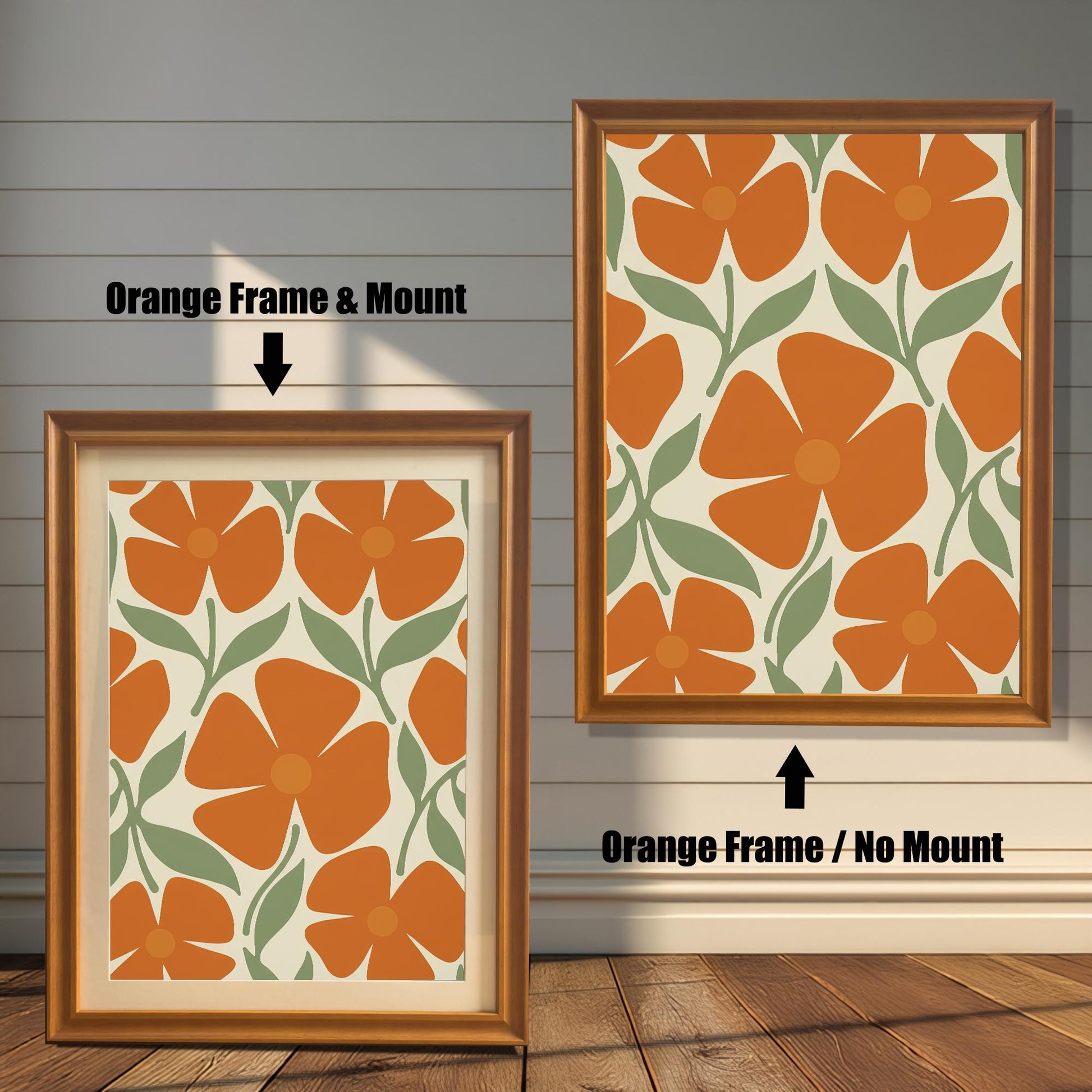 Two orange-colored framed art prints with a repeating pattern of orange flowers and green leaves. One has a white mat board and the other does not.