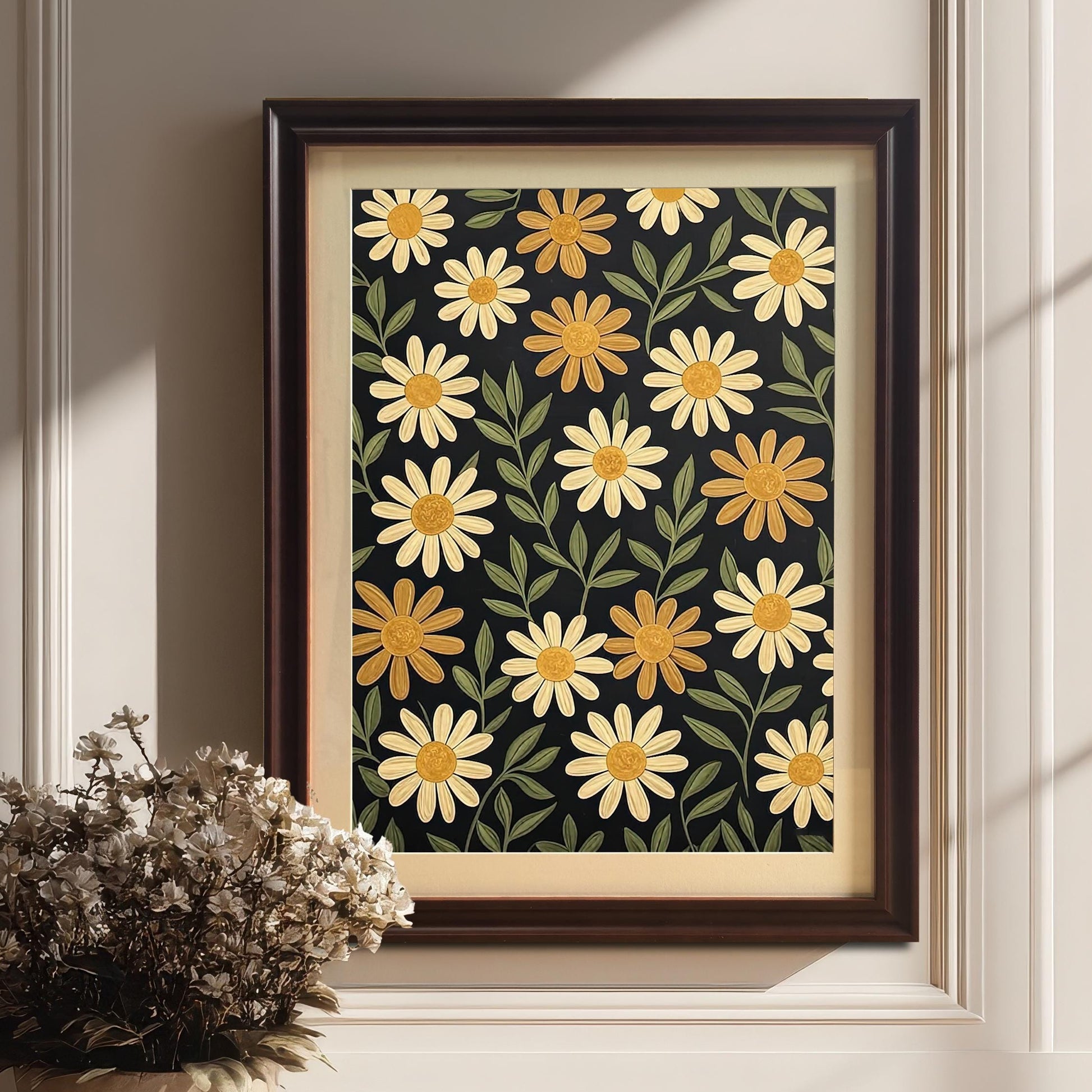 A framed, coffee-colored floral art print on a dark background. It's leaning against a white wainscoting wall next to a large potted plant.
