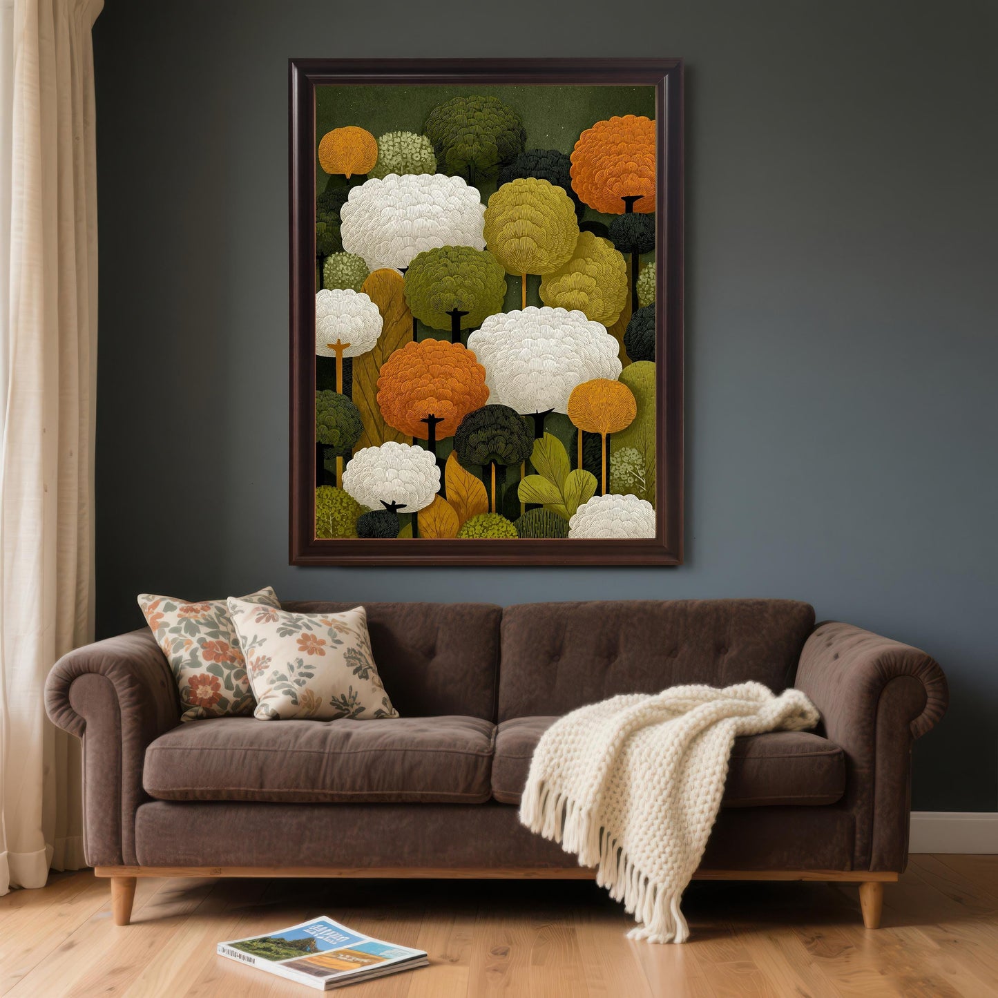A coffee-colored, framed art print of abstract trees hangs on a dark gray wall above a brown couch with pillows and a blanket.
