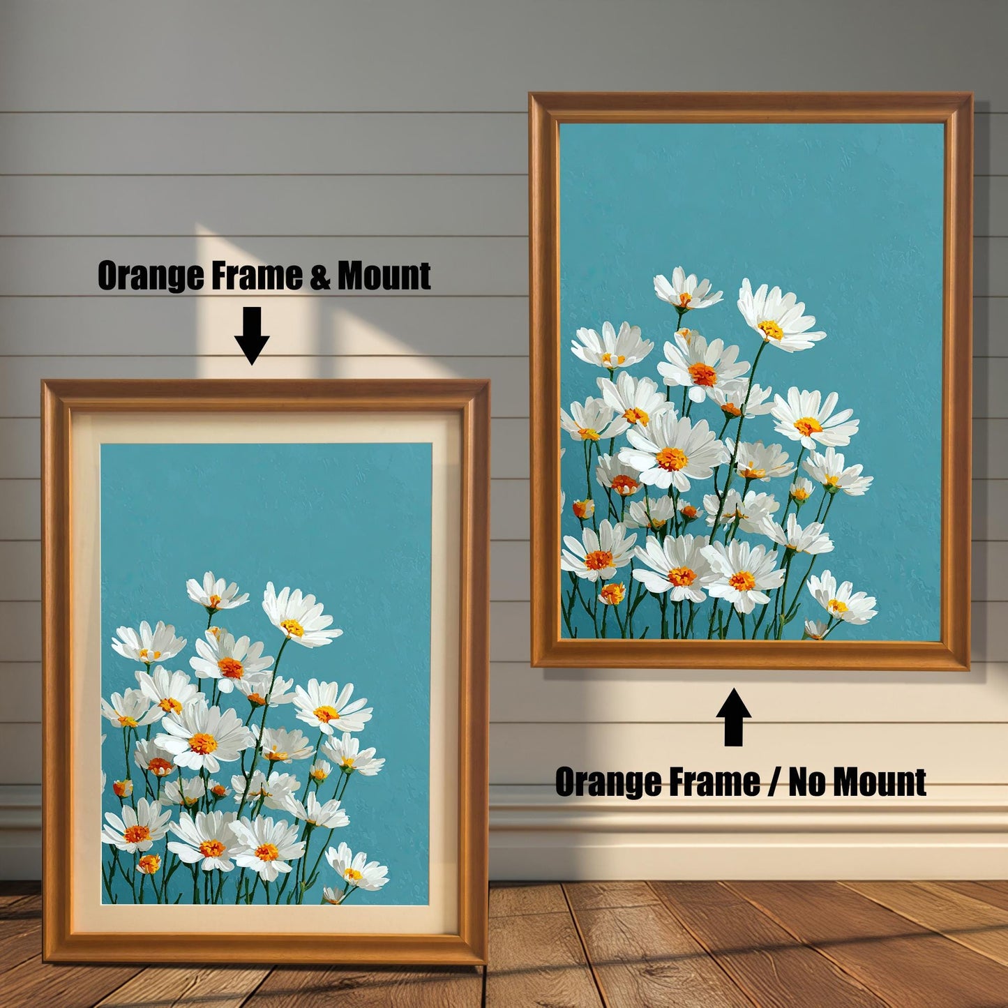 Two art prints of white daisies. The one on the left has an orange-colored frame with a white mat. The one on the right has an orange-colored frame with no mat.