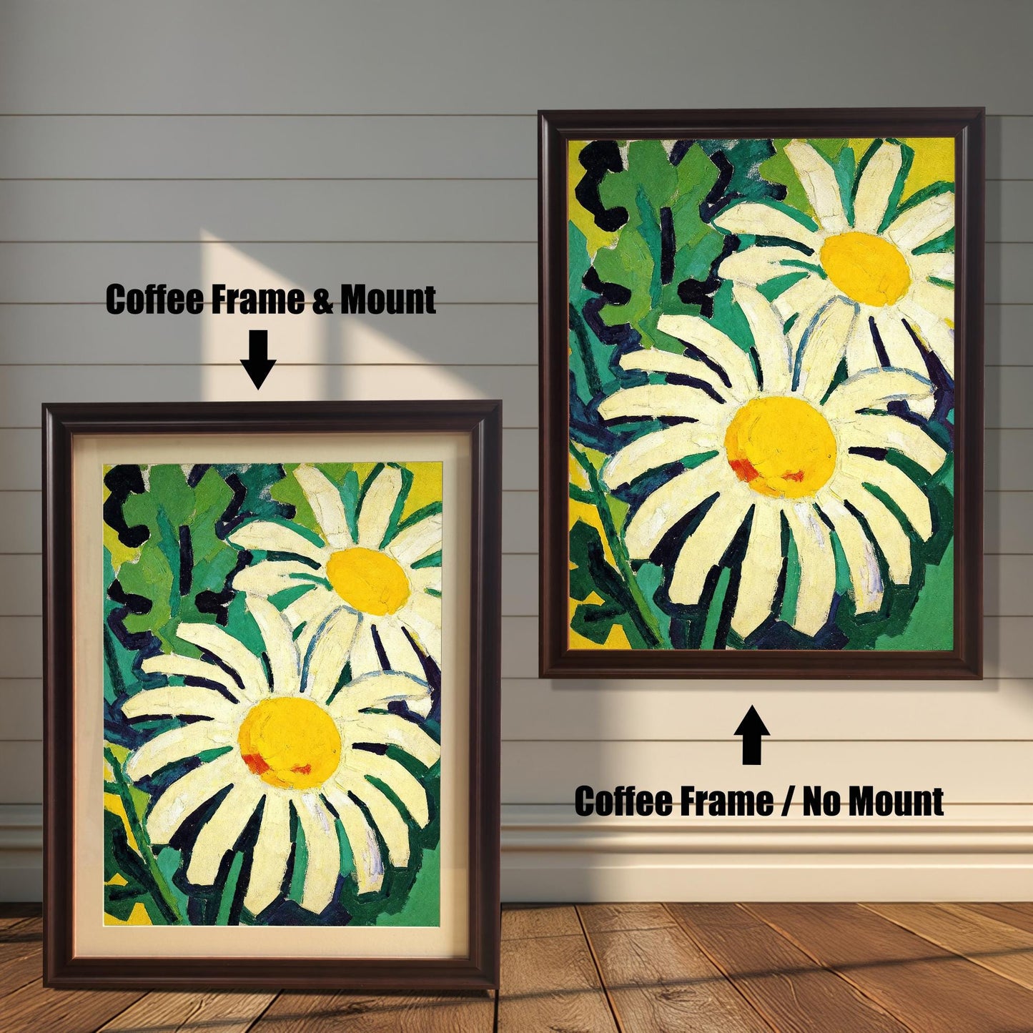 A framed painting of two daisies is shown in two styles against a wooden wall. One has a coffee-colored frame with a white mount, the other is a larger size with the same frame, but no mount.