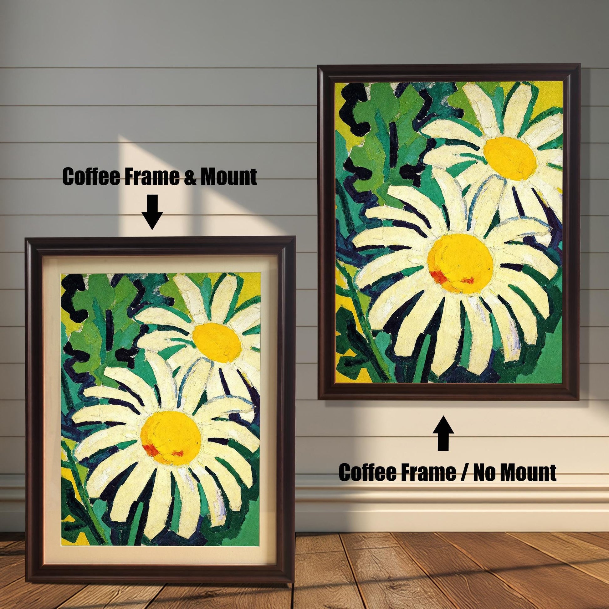 A framed painting of two daisies is shown in two styles against a wooden wall. One has a coffee-colored frame with a white mount, the other is a larger size with the same frame, but no mount.